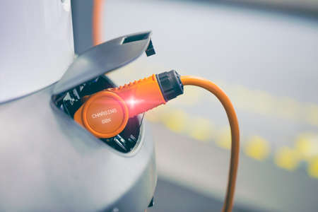 EV Car or Electric car at charging station with the power cable supply plugged in, Modern Eco-friendly energy driving vehicleの写真素材
