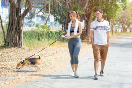 People couple walking with friendly pet beagle dog modern family morning activity for healthy.の写真素材