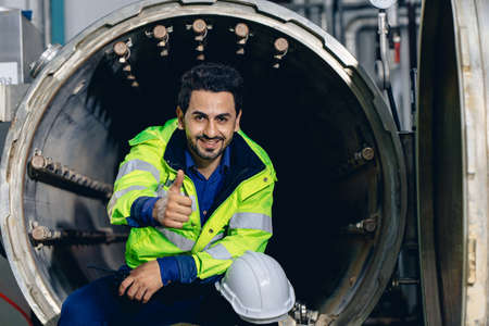 portrait engineer worker happy smiling working in factory sitting relax thumbs upの写真素材
