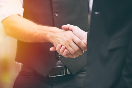closeup business people male hand shaking deal project working together