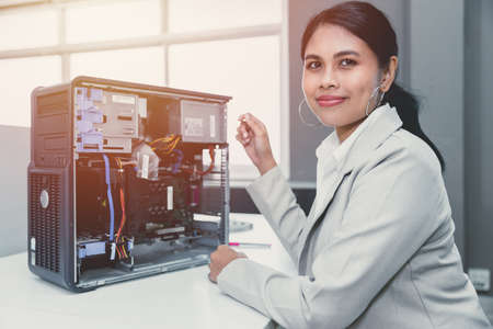 IT women staff officer work in office computer hardware fix repair service working happy smileの写真素材