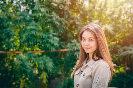 Woman in Cannabis agriculture farm, Girl teen with Marijuana or Hemp green herbal plant happy smile.の写真素材