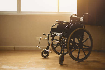 wheelchair in hospital room at windows morning sun lightの写真素材
