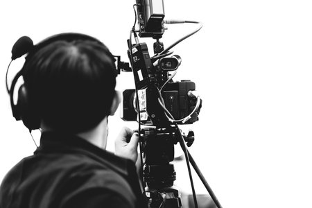 Camera man using professional video camcorder in media broadcasting industry black on white