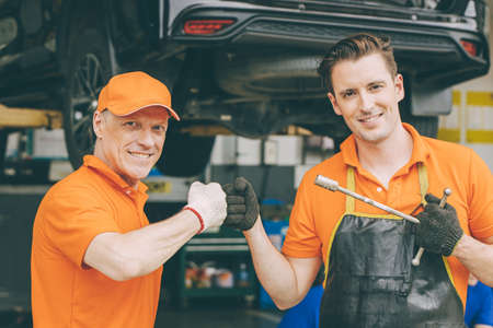 happy car mechanic service team enjoy working together in garageの写真素材
