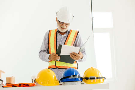 Professional senior engineer builder old man work looking at contract detail document paperの写真素材