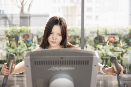 Asian woman walking at treadmill machine. Healthy girl fitness exercise holiday at gym.