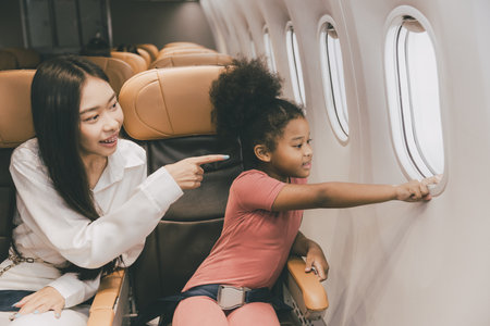 people with child kid happy looking window during air flight holiday travelの写真素材