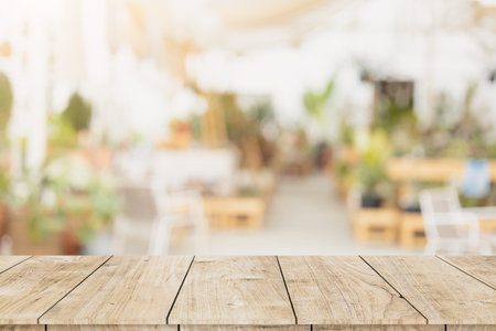 wooden table space with blur white clean cozy cafe and restaurant for advertising products montage...