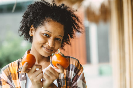 african black teen girl portrait with tomato healthy vetetable food for high vitaminの写真素材