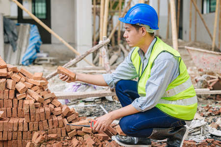 Engineer foreman manager quality check Burnt Clay Bricks for good construction building projectの写真素材