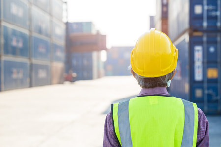senior worker vision looking at work place port shipping cargo container yard from back view with...