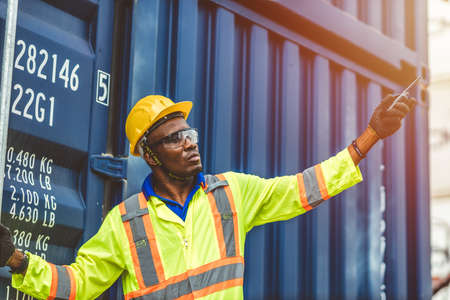 Foreman control loading Containers Cargo box freight ship for import export, black worker work in Container Cargo freight shipping Industry .の写真素材
