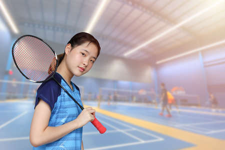 Badminton Athlete Asian player teen girl cute smiling portrait with indoor sport badminton court backgroundの写真素材