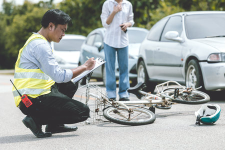 woman driver shock with car accident hit bicycle on the road claim police officer working collecting data at the sceneの写真素材