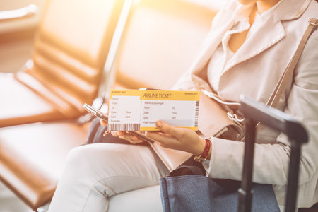 traveller sitting in waiting area with boarding pass ticket self check in using smartphone applicationの写真素材