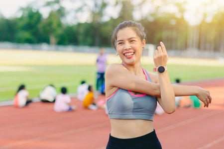 happy smile sport women healthy lifestyle. Asian woman shoulder stretching exercise activity outdoors.の写真素材