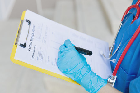 Doctor nurse writing followup information in medical examination document for patient health check in hospital or clinic.の写真素材