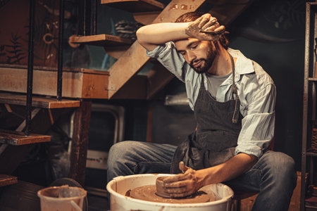 pottery worker male hand crafted made cray pot with tired exhausted from hard work over night tryの写真素材