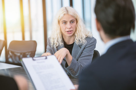 Young business woman focused eyes confident talk to your boss attentively in office meeting room for job interviewの写真素材