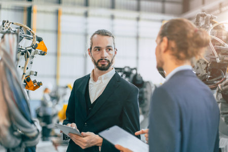 Businessman working in machinery factory robot assembly plant team working togetherの写真素材