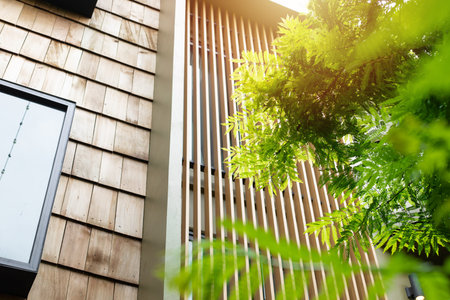 Modern home with wooden wall wooden slats and green tree for cooling sunshade and saving energy house exteriorの写真素材
