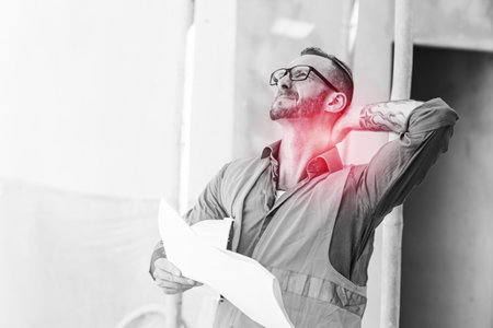 Adult senior construction builder male worker neck pain physical injury syndrome from hard workingの写真素材