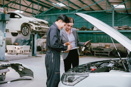 People working estimate repair cost in auto shop. Garage business owner car insurance claim team for help service fix repair broken car.の写真素材