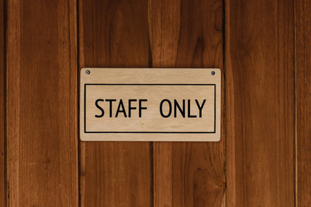 STAFF ONLY wood text badge sign banner on wooden door panel background.の写真素材