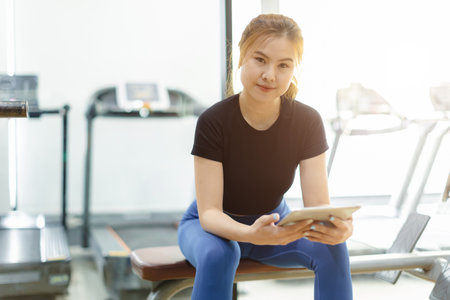 portrait sport healthy asian woman gym personal trainer woman with training program, sport club business owner confident.の写真素材