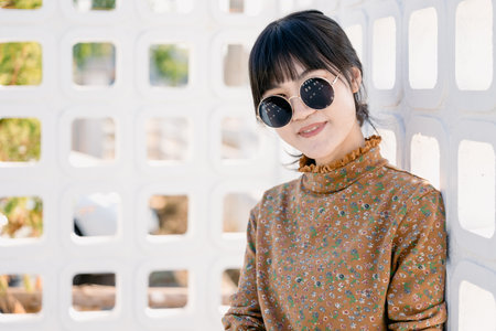 Asian teen waring round sunglasses in vintage style dress summer fashion collection model portrait.の写真素材
