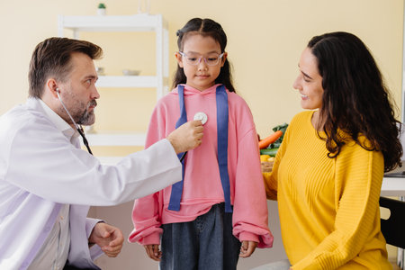Mother with daughter meeting pediatrician doctor at the clinic for health check talking about mental problems.の写真素材