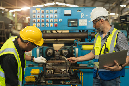 Engineer technician teamwork consulting problem together service maintenance old machine for safety in heavy industry factoryの写真素材