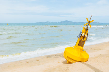 Ocean buoy environment sensor with CCTV camera out of service rest at sand beach waiting for repair maintenanceの写真素材