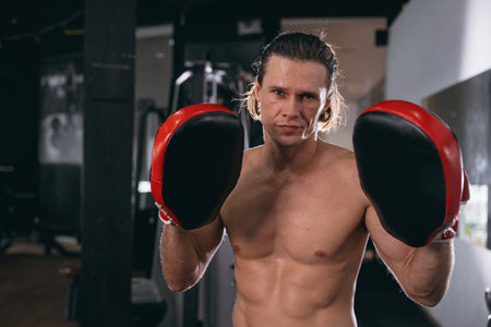 kickboxing athlete trainer portrait with boxing pad glove in fitness gym sport actionの写真素材
