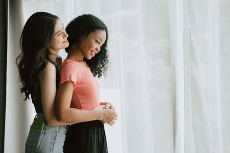 Women lover LGBTQ friend living together hands embrace at waist mix skin colorの写真素材