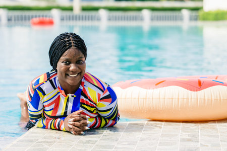 African woman happy relax at swimming pool summer holiday travel vacations. Black tourist girl...