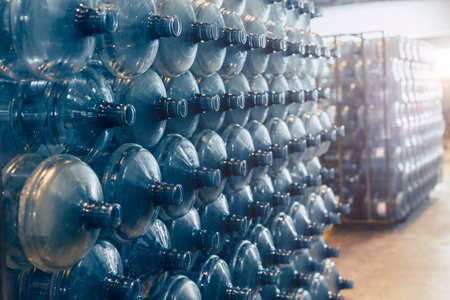 drinking water clean gallon bottles pile stacked in stock warehouse in drink water factory waiting in line for water bottling in plant.の写真素材