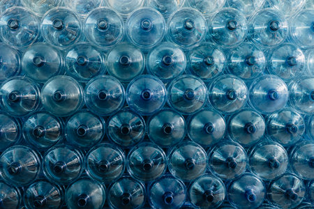 Water gallon pile stock. Plastic PET drinking bottle in drink water plant factory store in clean hygiene storage warehouse.の写真素材