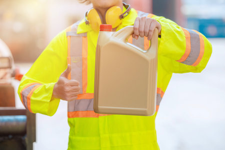 Engineer worker show Engine lube oil plastic bottle gallon hand thumb up for like good service products for industry advertisingの写真素材