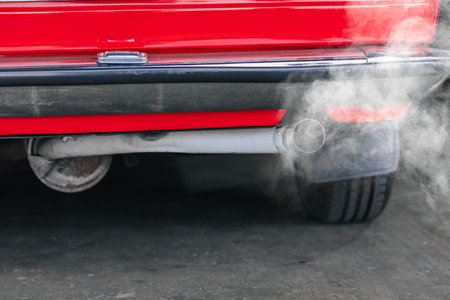 closeup old car rear exhaust pipe with smell smoke carbon monoxide bad air pollution lung diseaseの写真素材