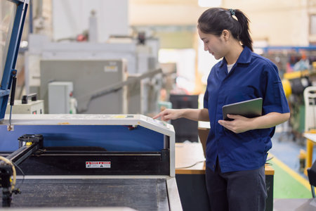 Asian women worker work in heavy industry with CNC lathe milling metal machine in steel product...