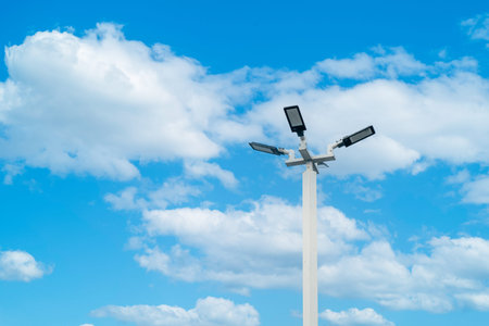 LED street lamp post ambient pole with bright blue sky cloud daylight background.