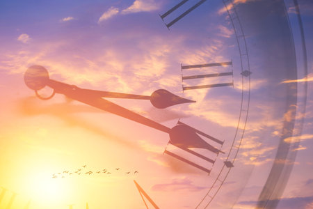 Clock face memory time in sun bright sky. Time passing sunset or sunrise sky overlayの写真素材