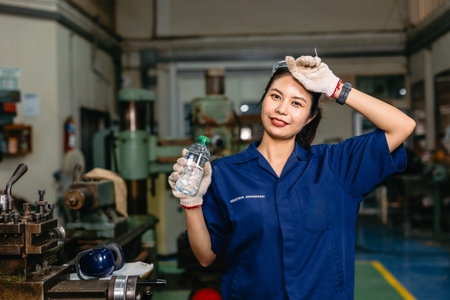 thirsty tired worker happy smiling drinking water relax rest at hot workplace metal workshop heavy...