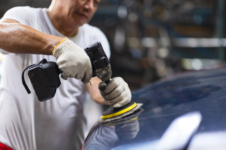 Car polishing, Worker in Auto workshop using color polisher machine. Polish coating wax in car care.の写真素材