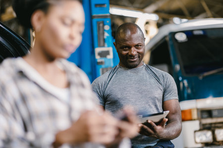 Woman takes car to repair in garage The mechanic looked happily. Overcharging the expensive car repair cost bill.の写真素材