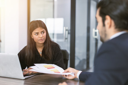 Indian business women talking with boss in office room, Marketing secretary work on the table with manager present information to decidingの写真素材