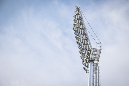 Stadium large high power lighting, Floodlights over a sports field outdoors against blue sky.の写真素材