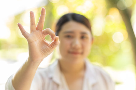 Women hand showing OK sign, Okay expression for pass approved confirm gesture happy smiling.の写真素材